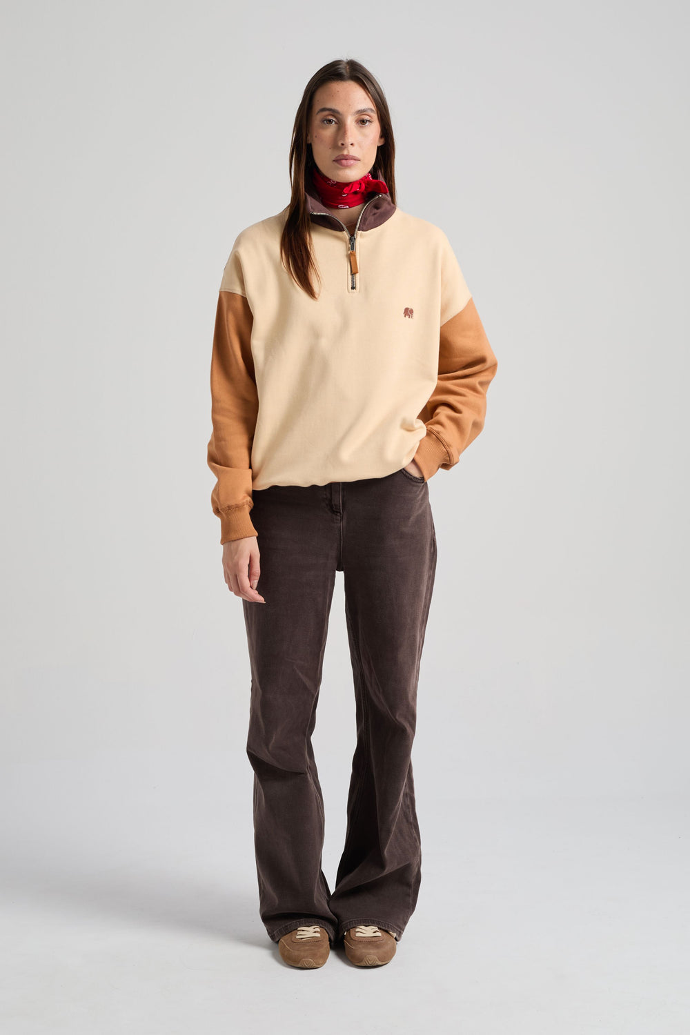 Persona che indossa una Women's Color Block Quarter Zip Sweatshirt in Gray Sand, abbinata a pantaloni scuri e a un bandana rossa, in posa su uno sfondo neutro | TP_IMAGE_TYPE=MODEL_FRONT