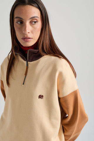 Persona che indossa una felpa con mezza zip da donna Color Block in gray sand, con un design elegante dalle maniche a contrasto e un piccolo logo sul petto. | TP_IMAGE_TYPE=MODEL_FRONT