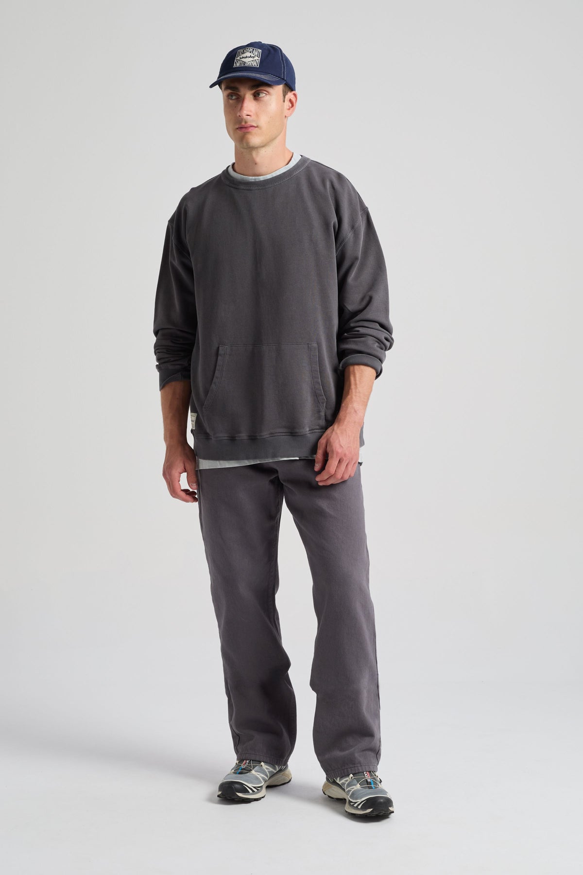 Personne portant un sweat-shirt Factory Oversized en Forged Iron, associé à un pantalon décontracté et des sneakers, debout devant un fond neutre. | TP_IMAGE_TYPE=MODEL_FRONT