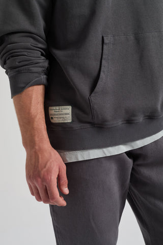 Personne portant un Factory Oversized Sweatshirt en Forged Iron, avec poche visible et détail d'étiquette | TP_IMAGE_TYPE=DETAIL