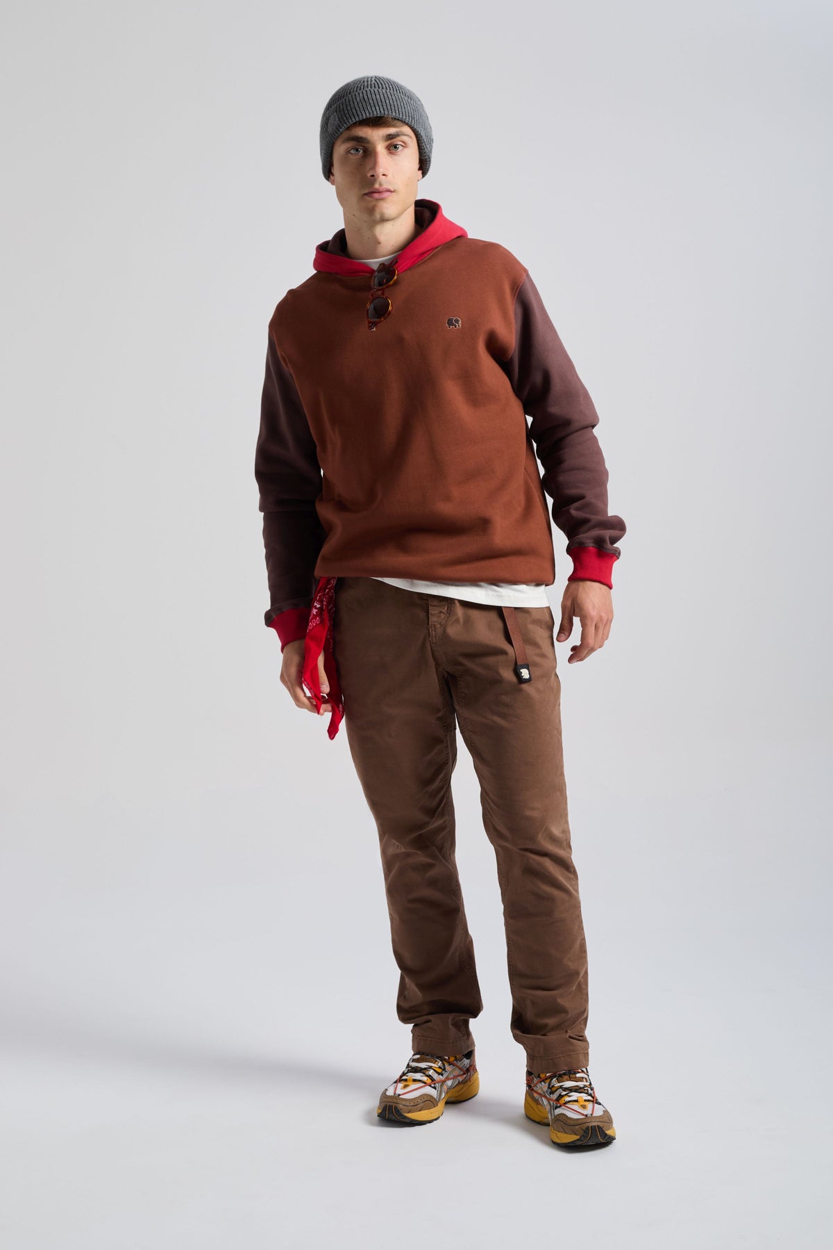 Persona che indossa una felpa con cappuccio Color Block in Cherry Mahogany, con cappuccio e vestibilità rilassata, abbinata a pantaloni marroni e a un berretto di tendenza | TP_IMAGE_TYPE=MODEL_FRONT