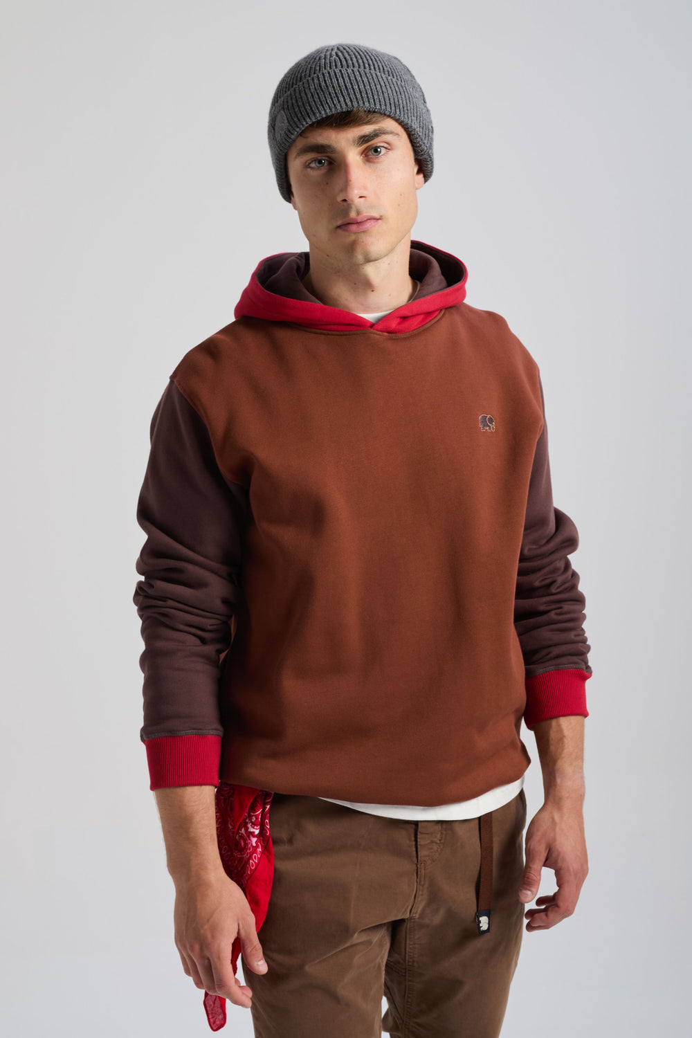 Persona che indossa una felpa con cappuccio Color Block nei colori cherry e mahogany, abbinata a una bandana rossa e a un berretto grigio | TP_IMAGE_TYPE=MODEL_FRONT