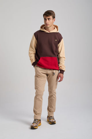 Personne portant un Color Block Hoodie en Solemnity Brown avec une poche rouge, associé à un pantalon beige et des baskets colorées | TP_IMAGE_TYPE=MODEL_FRONT