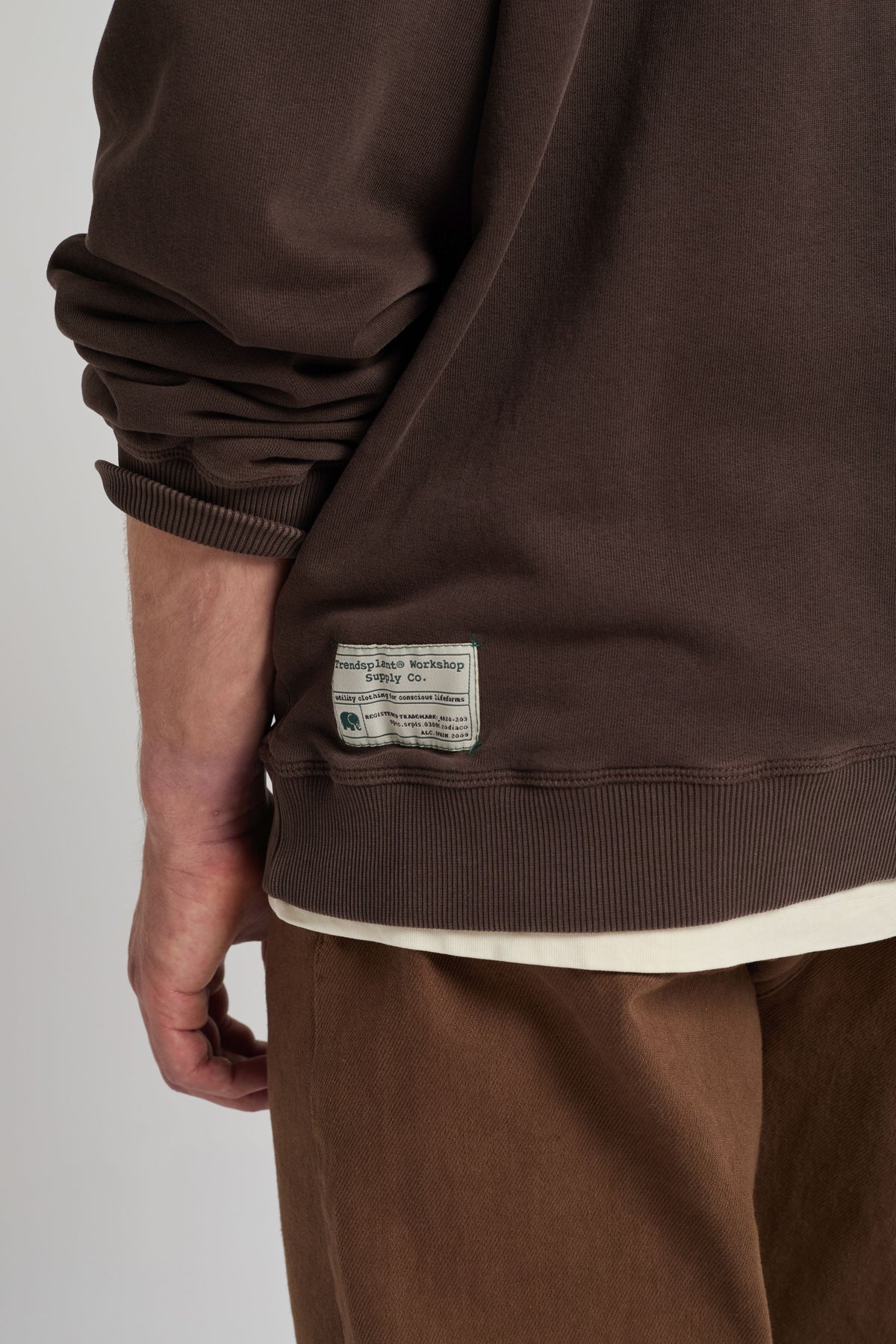 Personne portant un Core Oversized Sweatshirt en Coffee Bean, vue de dos avec une étiquette visible près de l'ourlet | TP_IMAGE_TYPE=MODEL_BACK