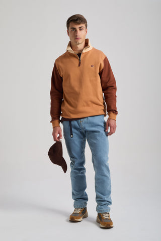 Personne portant un sweat à demi-zip color block en coloris Cashew avec des manches contrastantes et tenant une casquette marron | TP_IMAGE_TYPE=MODEL_FRONT