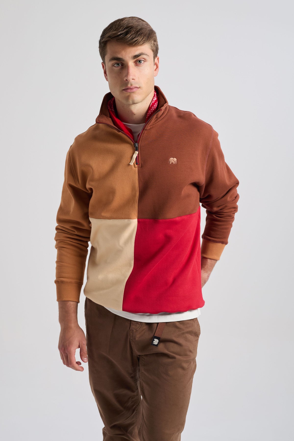 Personne portant un sweat-shirt à demi-zip à color block en Equestrian Red, aux nuances contrastées de rouge, beige et marron, agrémenté d'un bandana. | TP_IMAGE_TYPE=MODEL_FRONT