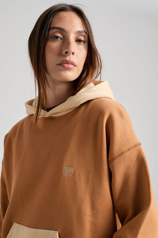 Personne portant un sweat à capuche color block pour femme en coloris cashew avec capuche beige et logo éléphant brodé | TP_IMAGE_TYPE=MODEL_FRONT