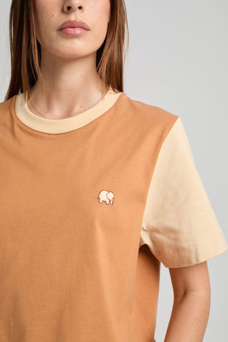 Personne portant un t-shirt femme color block en cashew avec un détail éléphant brodé, manches courtes et coupe décontractée. | TP_IMAGE_TYPE=MODEL_FRONT