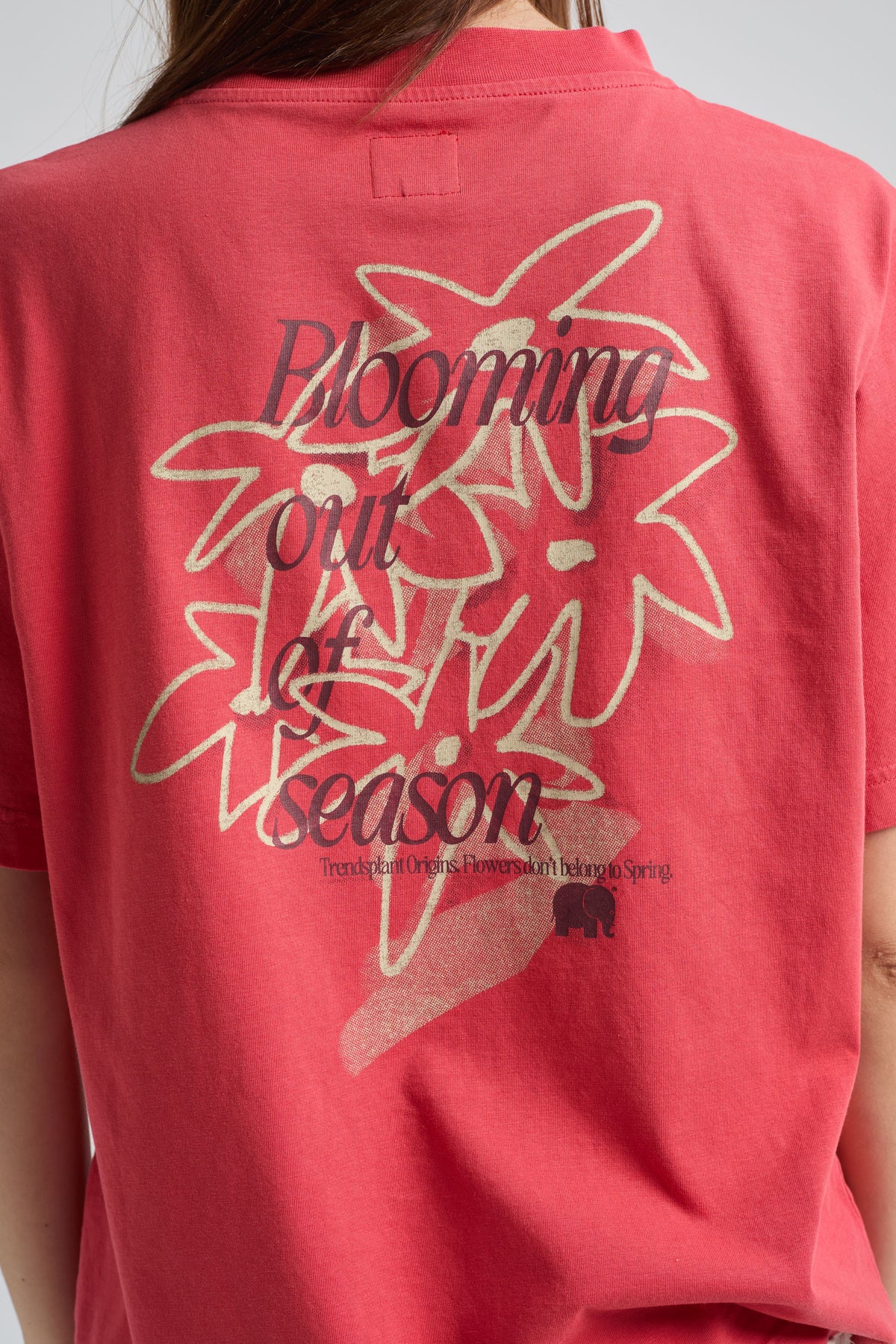 Persona che indossa una Poppy Red Women’s Bloom T-Shirt con stampa floreale e la scritta "Blooming out of season" sul retro, vista da dietro | TP_IMAGE_TYPE=MODEL_BACK