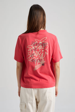 Persona che indossa la Women’s Bloom T-Shirt in Poppy Red, con una grafica floreale sul retro, vista da dietro. | TP_IMAGE_TYPE=MODEL_BACK