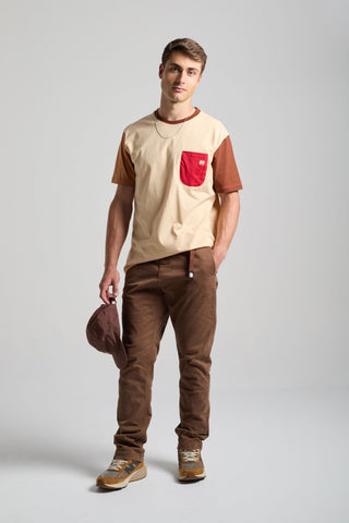 Personne portant un t-shirt color block gris sable avec des manches marron et une poche rouge, associé à un pantalon marron et une casquette assortie | TP_IMAGE_TYPE=MODEL_FRONT