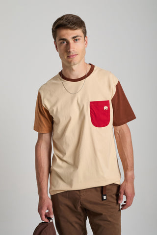 Personne portant un t-shirt color block gris sable avec des manches marron et une poche rouge, porté de façon décontractée avec un collier à chaîne. | TP_IMAGE_TYPE=MODEL_FRONT