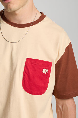 Personne portant un t-shirt à color block gris sable avec une poche rouge et un logo éléphant | TP_IMAGE_TYPE=MODEL_FRONT