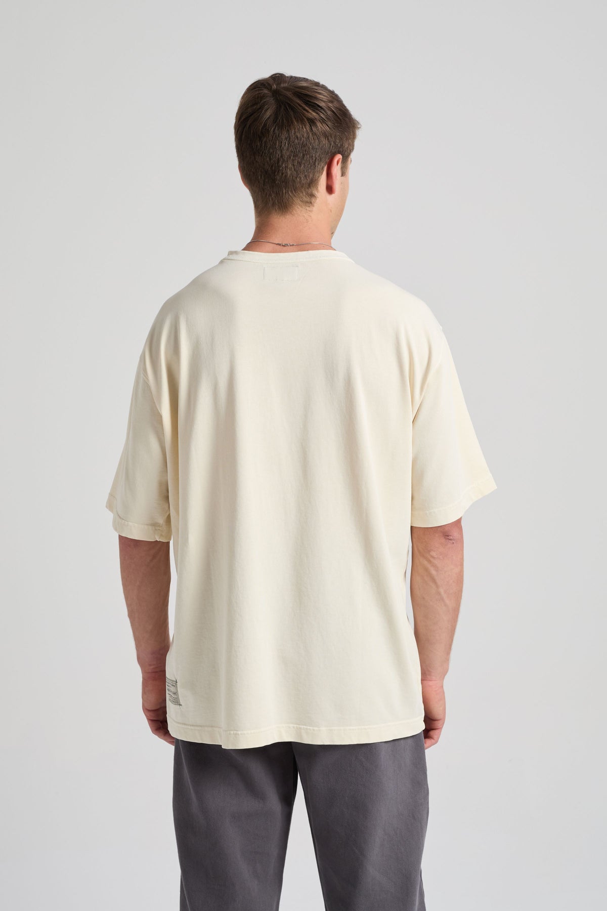 Persona che indossa una t-shirt oversize bianco sporco, vista posteriore | TP_IMAGE_TYPE=MODEL_BACK