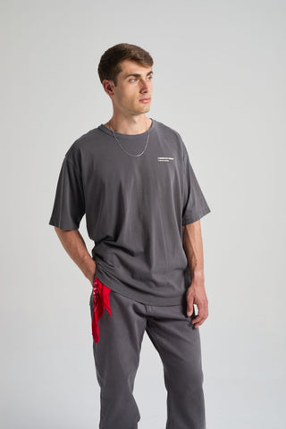 Persona che indossa una Core Oversized T-shirt in Forged Iron, abbinata a una catena argentata e a un bandana rosso. | TP_IMAGE_TYPE=MODEL_FRONT