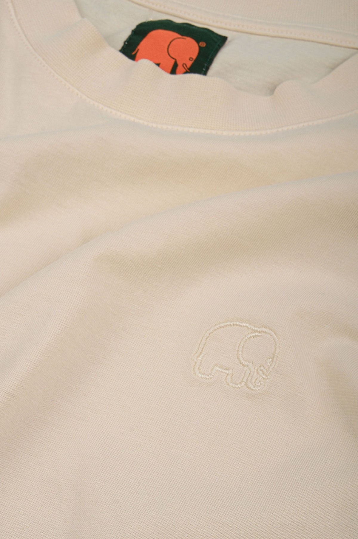 Silueta de la camiseta Essential Garment para mujer en Pearled Ivory con logo de elefante bordado | TP_IMAGE_TYPE=SILHOUETTE_FRONT