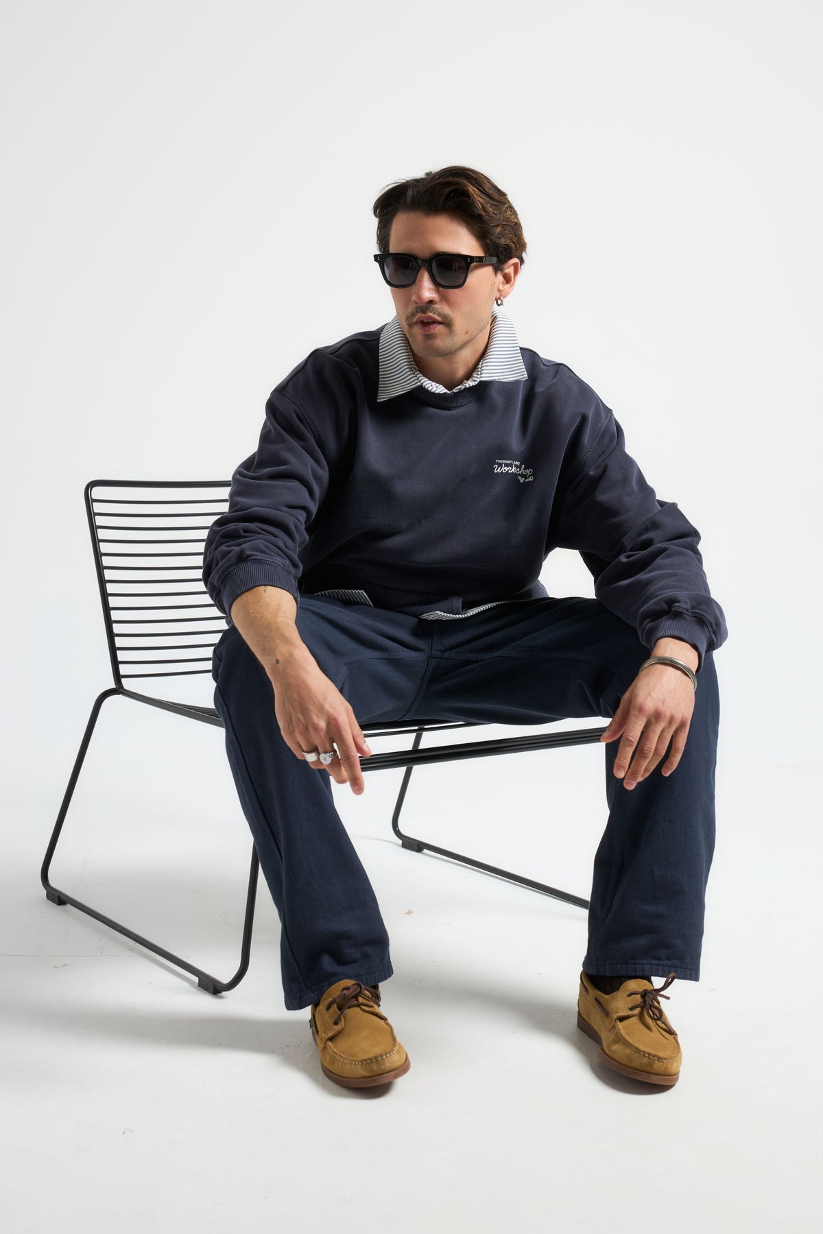 Personne portant The Garage Sweatshirt en Baritone Blue, en position assise avec des lunettes de soleil | TP_IMAGE_TYPE=MODEL_FRONT