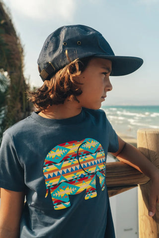Personne portant un Kid's Organic Navajo Classic T-Shirt Trendsplant Blue, avec un motif d'éléphant coloré, vue de côté | TP_IMAGE_TYPE=MODEL_FRONT