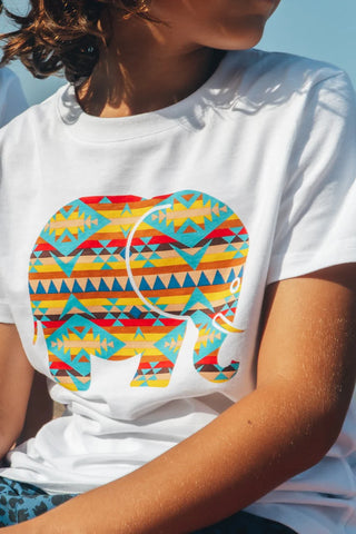 Persona che indossa una t-shirt classica Navajo biologica bianca con un colorato disegno di elefante | TP_IMAGE_TYPE=MODEL_FRONT