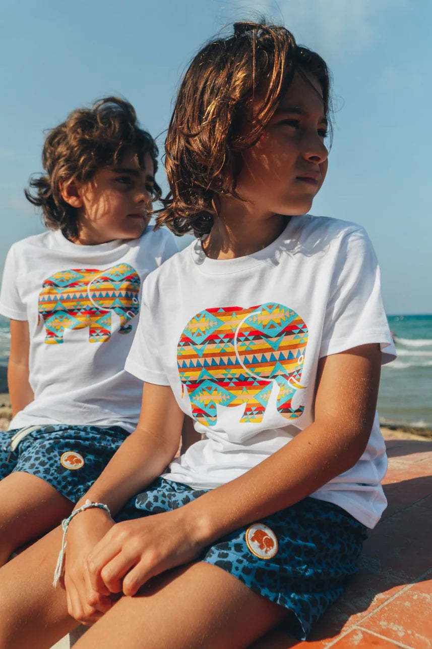 Persona che indossa una Kid's Organic Navajo Classic T-Shirt bianca con un disegno colorato di un elefante | TP_IMAGE_TYPE=MODEL_FRONT