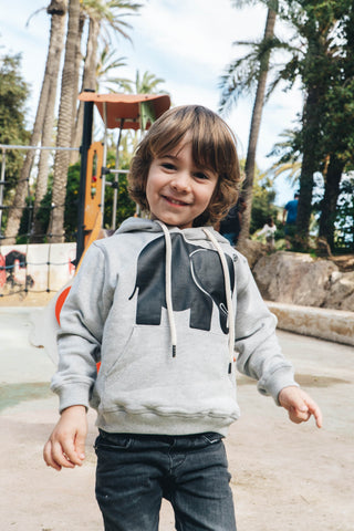 Persona che indossa una Kid's Organic Classic Hoodie Heather Grey, vista frontale | TP_IMAGE_TYPE=MODEL_FRONT