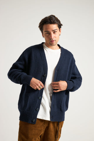 Personne portant le Relleu Cardigan en bleu marine foncé, associé à un t-shirt blanc et arborant un look décontracté | TP_IMAGE_TYPE=MODEL_FRONT