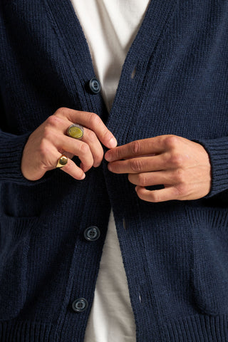 Personne portant un cardigan Relleu bleu marine foncé, ajustant les boutons, mettant en valeur une texture tricotée complexe et arborant des bagues élégantes aux doigts. | TP_IMAGE_TYPE=MODEL_FRONT