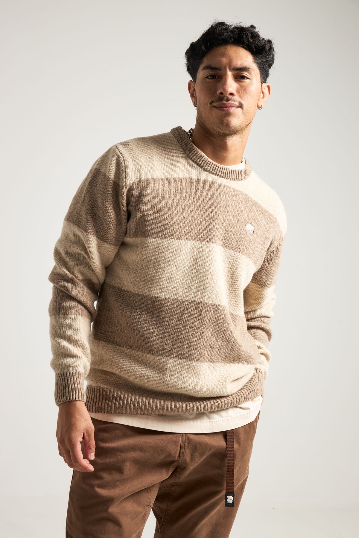 Persona che indossa il Sella Knit in Latte/Nomad Brown, con vestibilità relaxed e motivo a righe. | TP_IMAGE_TYPE=MODEL_FRONT