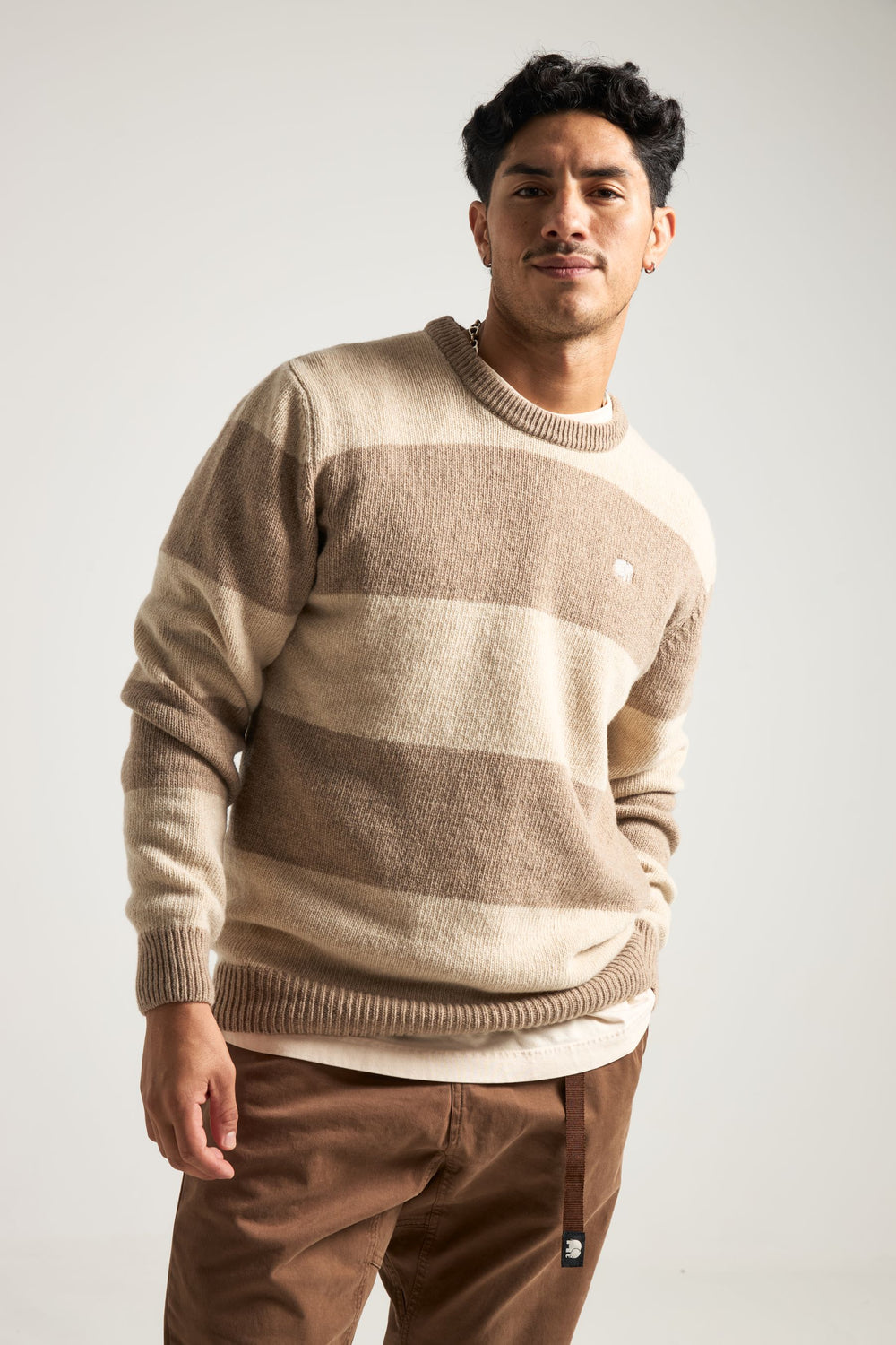 Persona che indossa il Sella Knit in Latte/Nomad Brown, con vestibilità relaxed e motivo a righe. | TP_IMAGE_TYPE=MODEL_FRONT