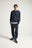 Personne portant un Organic Essential Sweatshirt en coloris Trendsplant Blue, les mains dans les poches, sur un fond uni. | TP_IMAGE_TYPE=MODEL_FRONT