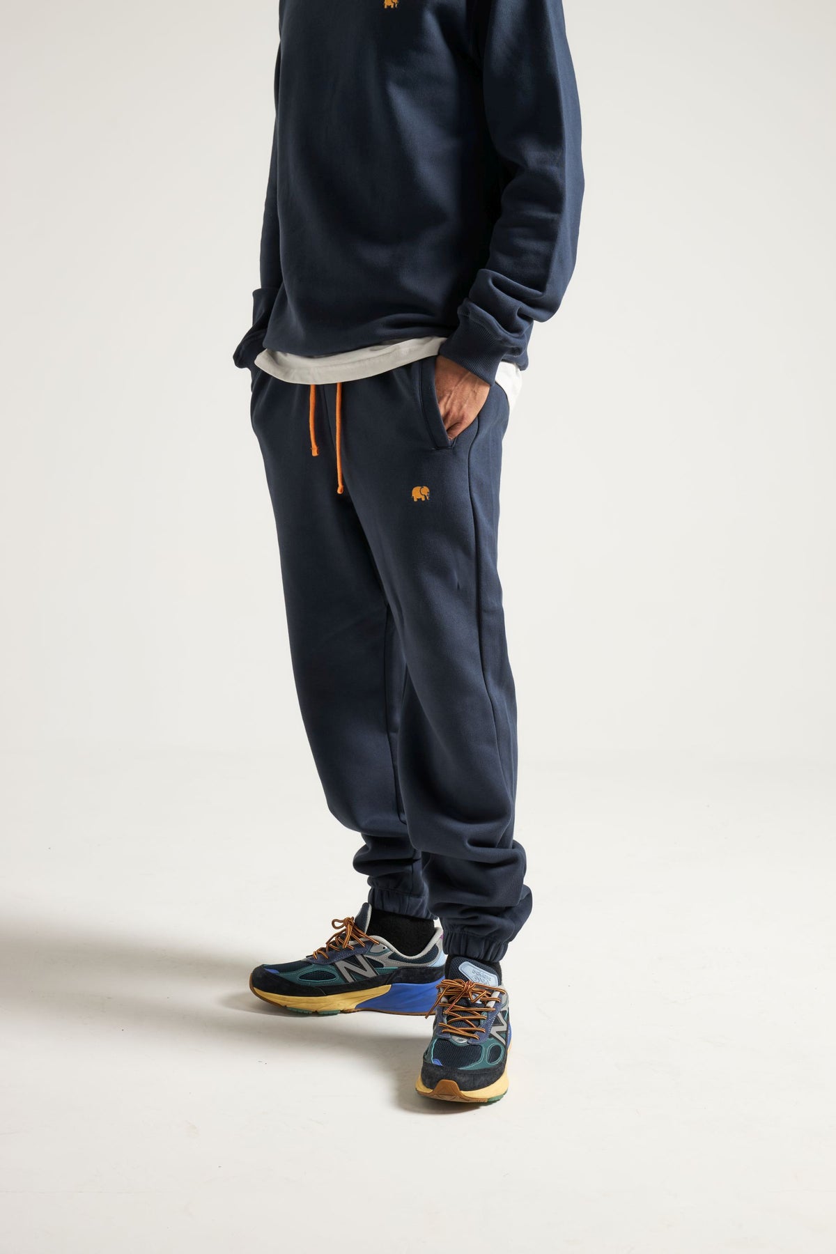 Persona che indossa Organic Essential Sweatpants in Trendsplant Blue con felpa e sneakers abbinate | TP_IMAGE_TYPE=MODEL_FRONT