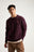 Persona che indossa un maglione Sella Knit rosso vino, in piedi con le mani in tasca e sfondo neutro | TP_IMAGE_TYPE=MODEL_FRONT