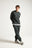 Personne portant un Organic Essential Sweatshirt en Scarab Green, associé à un pantalon assorti, dans une pose décontractée | TP_IMAGE_TYPE=MODEL_FRONT