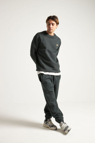 Personne portant un Organic Essential Sweatshirt en Scarab Green, associé à un pantalon assorti, dans une pose décontractée | TP_IMAGE_TYPE=MODEL_FRONT