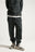Persona che indossa Organic Essential Sweatpants in Scarab Green, con una vestibilità comoda ed elegante e chiusura con coulisse. | TP_IMAGE_TYPE=MODEL_FRONT