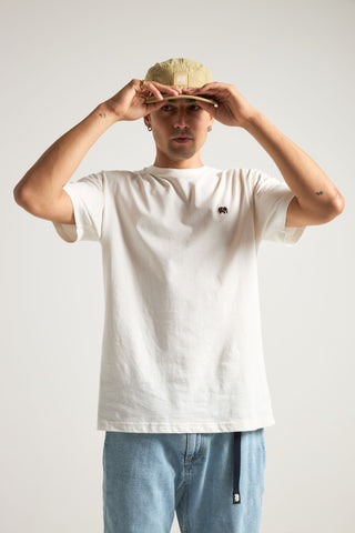 Persona che indossa una t-shirt essenziale biologica in colore naturale, abbinata a un cappellino e jeans blu casual | TP_IMAGE_TYPE=MODEL_FRONT