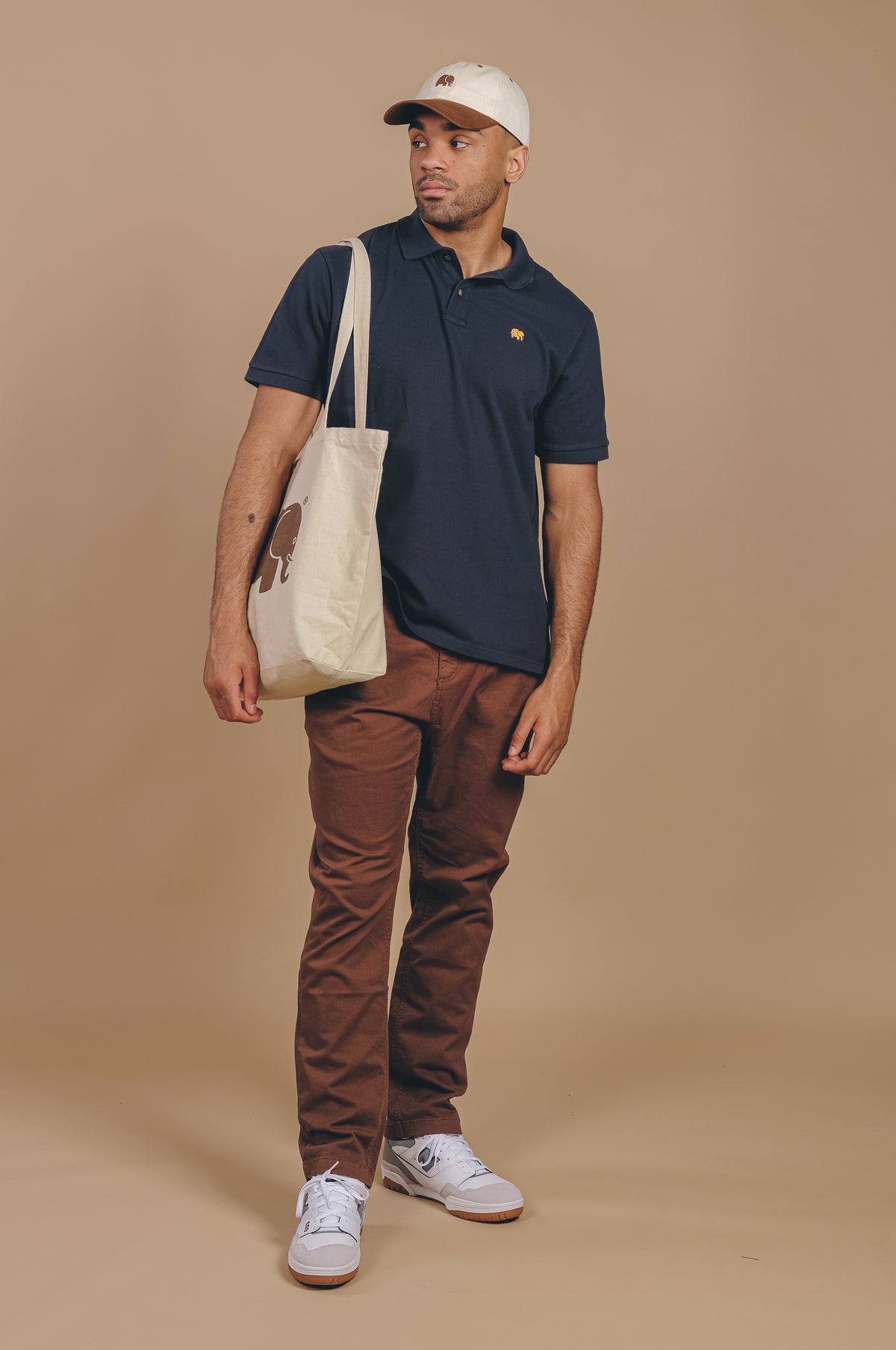 Personne portant une chemise polo Organic Essential Polo Shirt en bleu Trendsplant Blue, associée à un pantalon marron décontracté, debout avec assurance | TP_IMAGE_TYPE=MODEL_FRONT