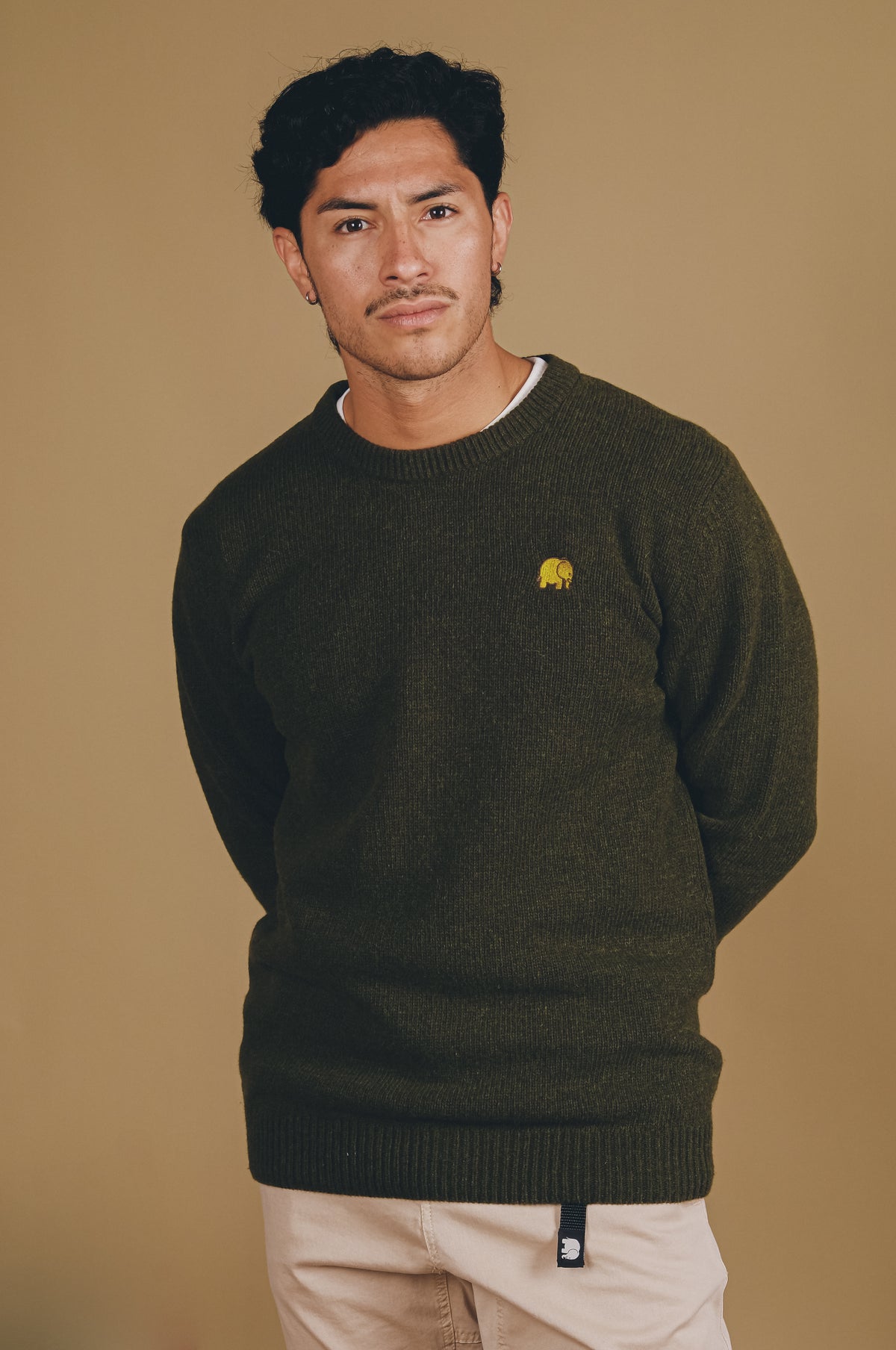 Personne portant le Sella Knit en Ivy Green, avec un design confortable et un petit logo jaune sur la poitrine | TP_IMAGE_TYPE=MODEL_FRONT