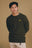 Persona che indossa il Sella Knit in Ivy Green, con un design accogliente e un piccolo logo giallo sul petto | TP_IMAGE_TYPE=MODEL_FRONT