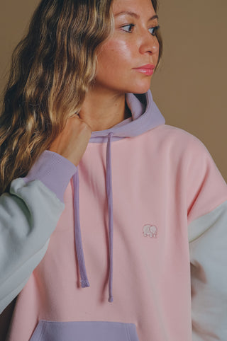 Persona che indossa una Women's Oversized Color Block Hoodie Pink, vista frontale con una palette di colori pastello | TP_IMAGE_TYPE=MODEL_FRONT