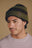 Persona che indossa il Montcabrer Beanie in Khaki/Coffee, con design a righe e dettaglio logo, in una foto ravvicinata. | TP_IMAGE_TYPE=MODEL_FRONT