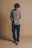 Person wearing the Tarbena Knit Stone sweater styled with blue pants, standing with hands clasped in front of a neutral background. | TP_IMAGE_TYPE=MODEL_FRONT