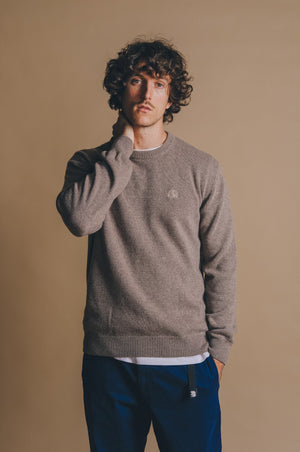 Person wearing the Tarbena Knit Stone sweater, posing with a thoughtful expression against a neutral background. | TP_IMAGE_TYPE=MODEL_FRONT