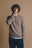 Person wearing the Tarbena Knit Stone sweater, posing with a thoughtful expression against a neutral background. | TP_IMAGE_TYPE=MODEL_FRONT