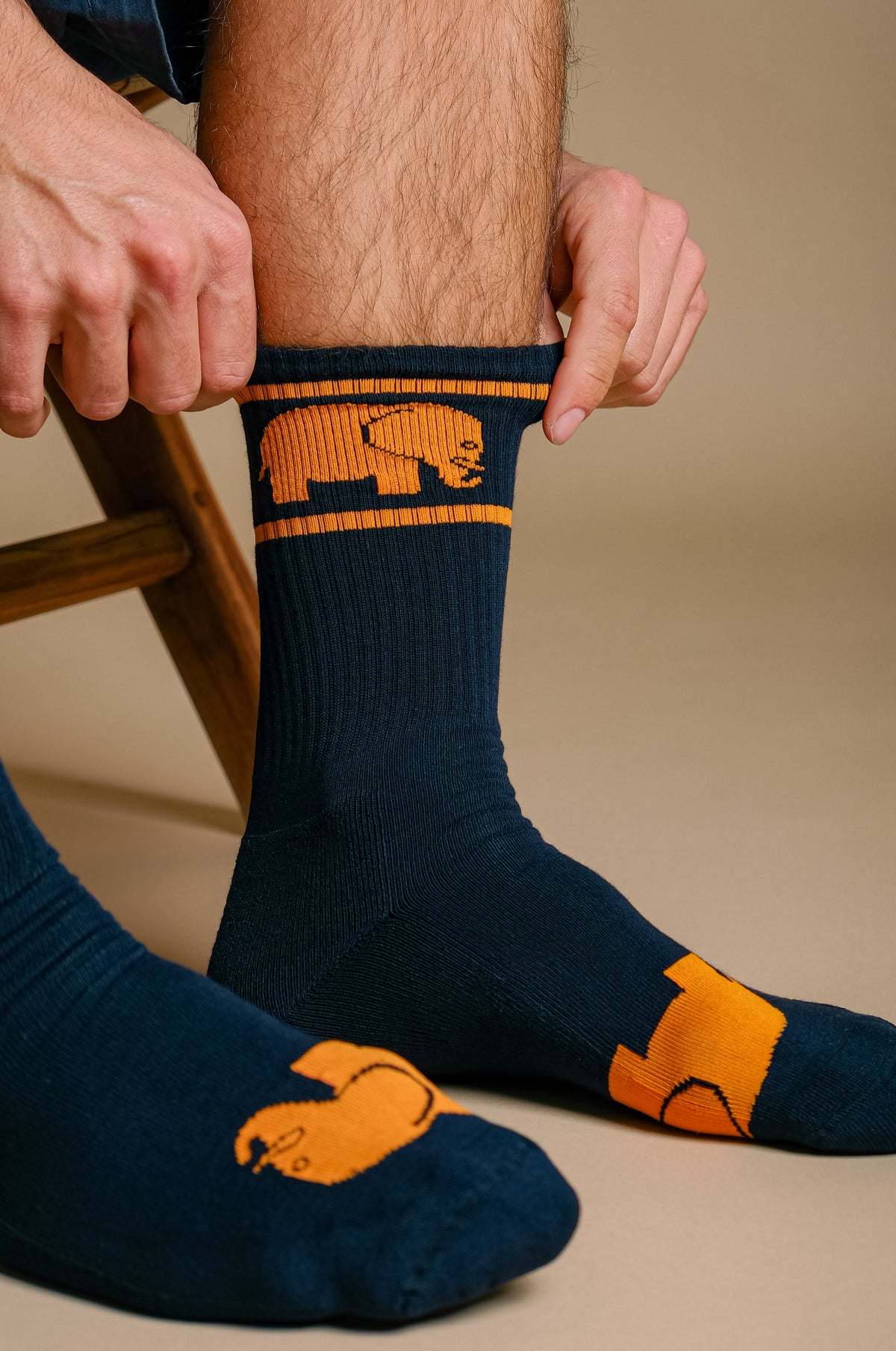 Personne portant des chaussettes de sport en bambou bleu marine, ajustant la tige | TP_IMAGE_TYPE=MODEL_FRONT