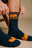 Personne portant des chaussettes de sport en bambou bleu marine, ajustant la tige | TP_IMAGE_TYPE=MODEL_FRONT