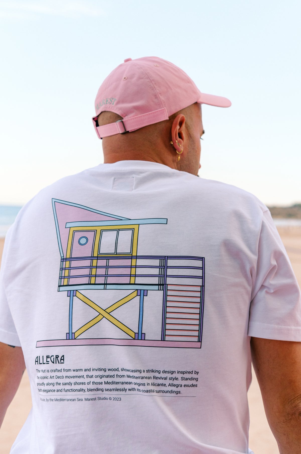 Persona che indossa una T-shirt Allegra Hut con una grafica colorata, vista posteriore | TP_IMAGE_TYPE=MODEL_BACK
