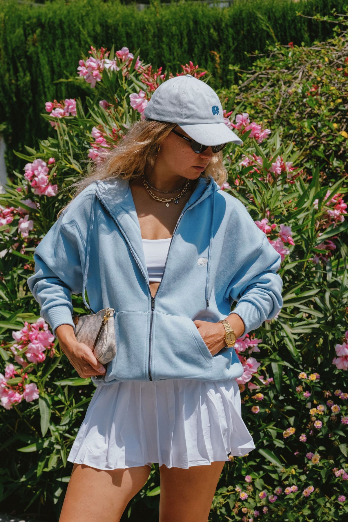 Persona che indossa un Logo Dad Cap Sky Blue con un outfit casual su uno sfondo floreale | TP_IMAGE_TYPE=LIFESTYLE