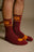 Persona che indossa calze sportive in cotone organico bordeaux con un motivo animale giocoso | TP_IMAGE_TYPE=MODEL_FRONT