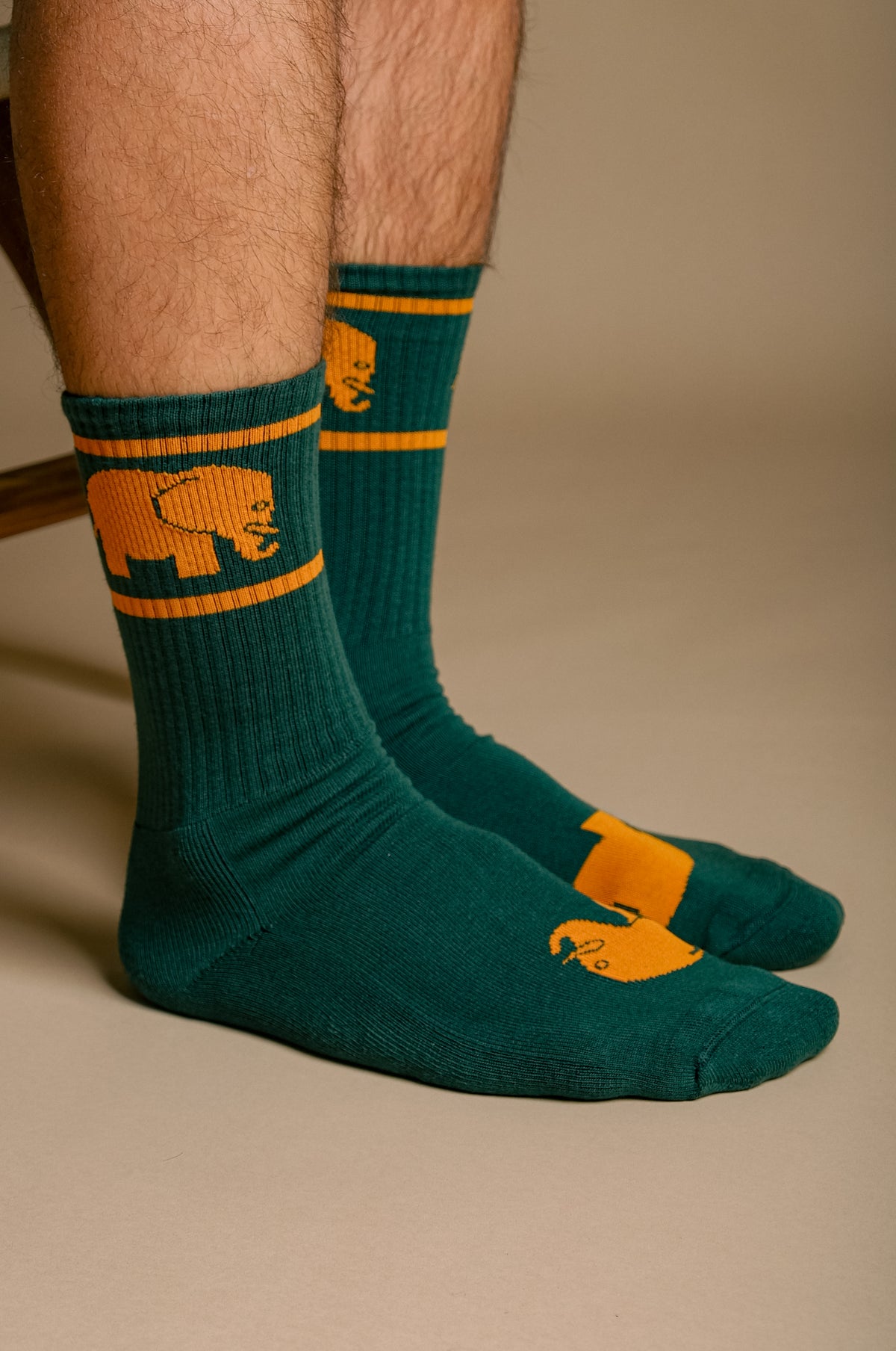 Personne portant des chaussettes de sport en coton biologique vert avec des motifs orange | TP_IMAGE_TYPE=MODEL_FRONT